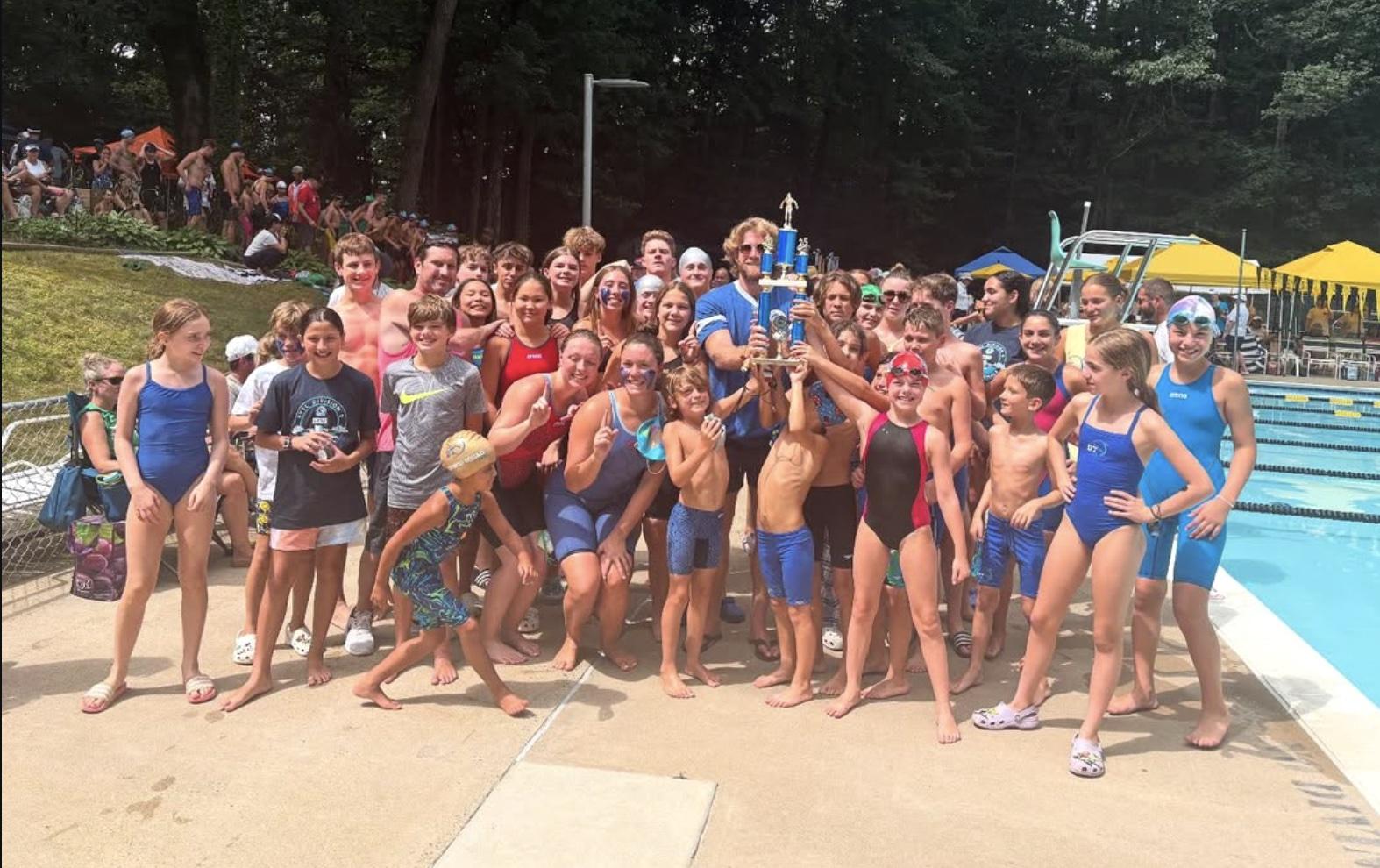The Dowden Terrace Dolphins swim team celebrating together beside the pool